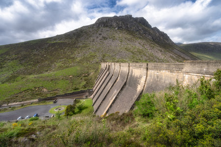 This stunning landscape features Silent Valley Reservoir dam in Mourn Mountains, surrounded by lush greenery and a dynamic sky, perfect for nature lovers and outdoor enthusiasts, Northern Irelandの写真素材