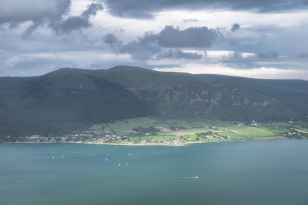 A serene fiord among green hills and villages, under a cloudy sky, creates an idyllic landscape ideal for relaxation and reflection on life and nature, Carlingford, Irelandの写真素材
