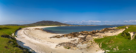 Sandy cove with turquoise Dogs Bay in Connemara, Galway, Ireland. Dunes, gentle waves lapping pale...