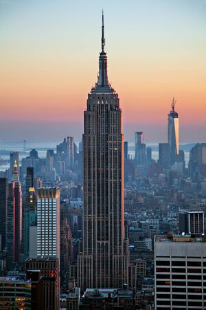 The Empire State Building silhouette among other skyscrapers of the Manhattan skyline on the background of the Hudson Bay at sunset under clear sky; in New York City, United States of Americaのeditorial素材
