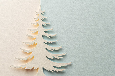 Elegant handmade paper cut Christmas tree with textured pastel background and ample copy spaceの素材