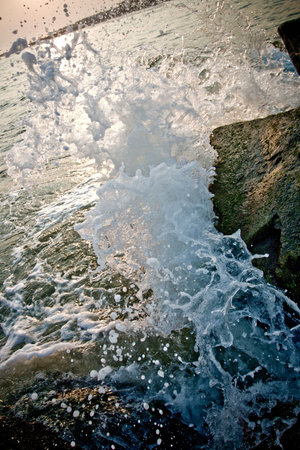 Hitting the rock jetty of the Cape May shoreline, a rogue wave splashes upwards upon impact.
