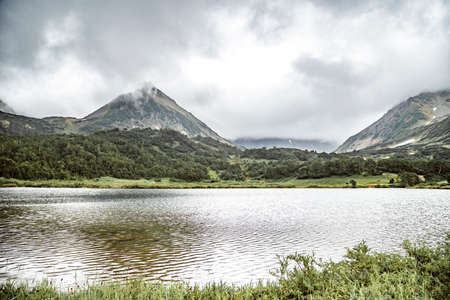 Volcanic landscape with green plains and lake on Kamchatka peninsula, Russiaの写真素材