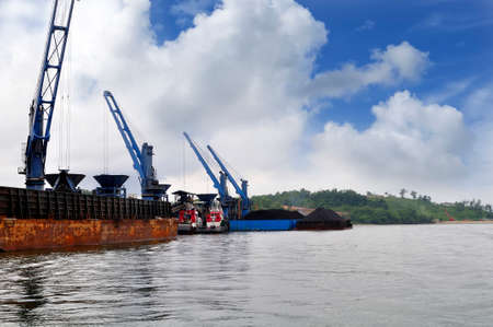 three coal barge was unloading cargo at the portの写真素材