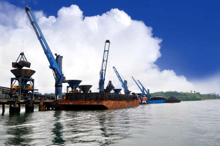 unloading coal from barge to hopper at the coal portの写真素材