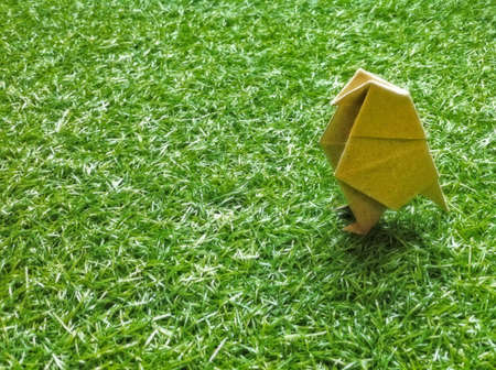 There is a origami bird on the grass.の素材