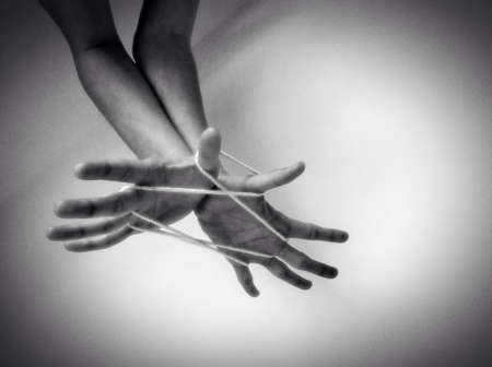 Hands playing string game.の素材