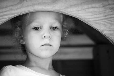 Little sad girl on the playground. Black and white series.の写真素材