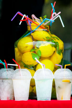 A large bottle of lemonade and glasses at the festival of street food.の写真素材