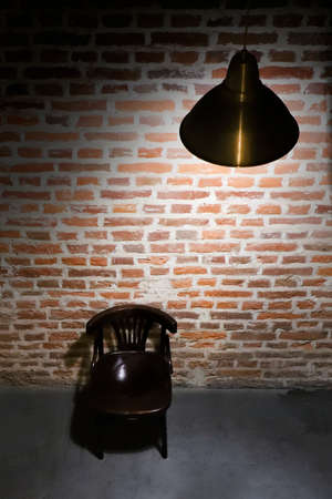 Empty abandoned room of red brick. A dark room with the light of a metal lamp.の写真素材