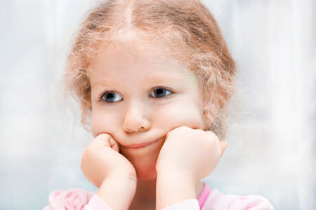 Little sad curly girl portrait, close up. の写真素材
