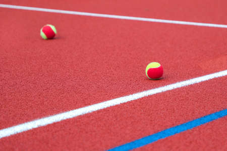 Red tennis court with tennis ball, artificial cover ,close up.の写真素材
