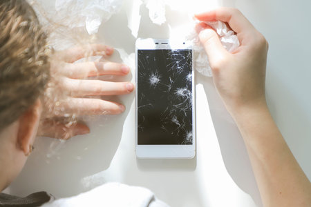 Crying girl with broken smart phone.