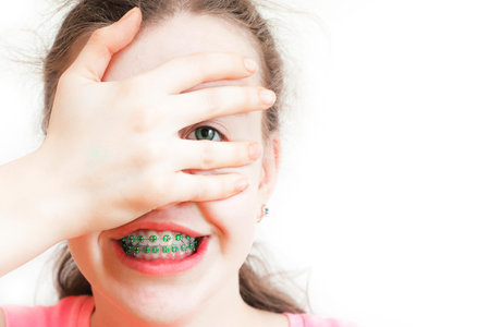 Teenage girl embarrassed and closes the mouth with her hands.