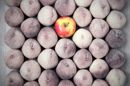 Peach and apple fruit background, healthy vegan food, close up. Stand out in the crowd.