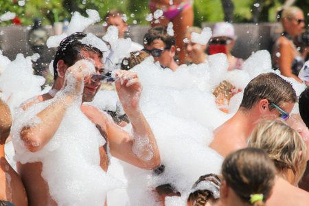 Belek, Turkey - August 04, 2016: Foam party on the beach. Many people in the foam.
