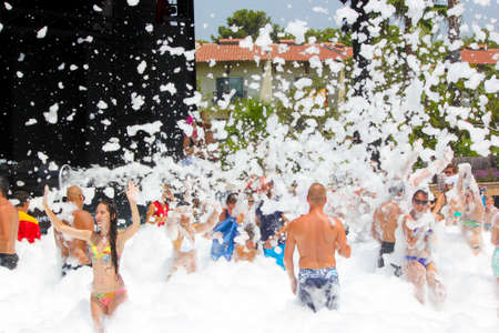 Belek, Turkey - August 04, 2016: Foam party on the beach. Many people in the foam.のeditorial素材