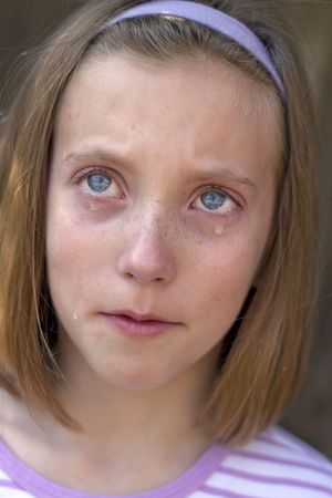 pretty young blue-eyed girl with tearsの写真素材