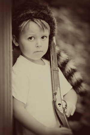 vintage child with toy rifle and coonskin cap