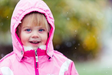 happy little girl bundled up for a snow dayの写真素材