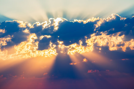 bright colored sunbeams behind the cloudsの写真素材
