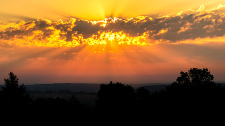 Crimson sunrise (sunset) bright rays of the sun breaking through the clouds