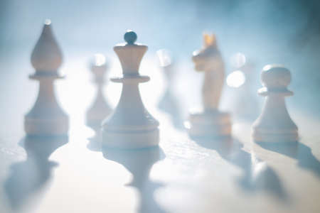 Silhouettes of chess pieces in the smoke of war. Blue haze and smoke or fog. Abstraction of the battle strategy. Business.の写真素材