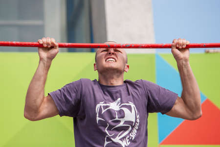 Minsk, Belarus -  May 18, 2014: The young man is pulled up out of his last strength. City sports festivalのeditorial素材