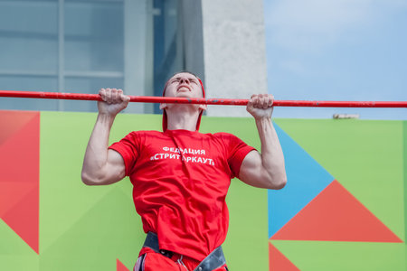 Minsk, Belarus -  May 18, 2014: The young man is pulled up out of his last strength. City sports...