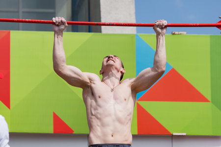 Minsk, Belarus -  May 18, 2014: The young man is pulled up out of his last strength. City sports...