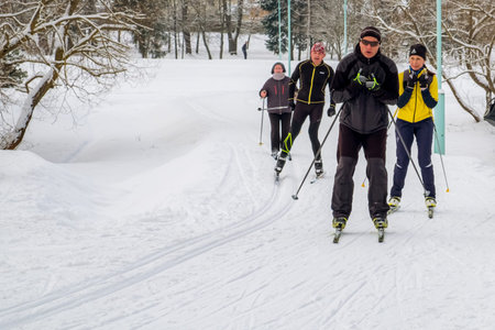 Minsk, Belarus - February 11, 2018: Active winter holidays. People of different ages, women and men, ski on the ski track in winter on their day off.のeditorial素材
