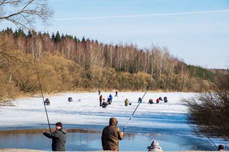 Minsk region, Belarus - March 25, 2018: Fishermen in early spring. some on the shore and others on the ice in March. Belarusのeditorial素材