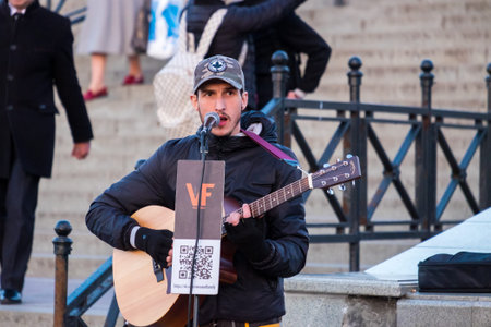 Minsk, Belarus - April 13, 2018: A street musician. A cute young guy plays guitar and sings on the...