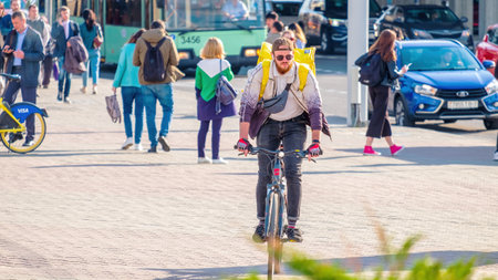 Minsk, Belarus - May 31, 2022: Delivery man on a bike on a busy city streetのeditorial素材