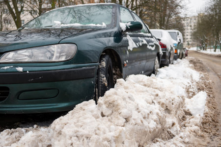 Winter. The road is covered with snow. Cars parked along the roadside and covered with snowの写真素材