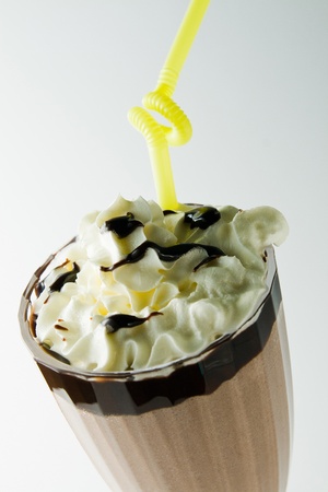glass of coffee with cream and yellow tubuleの写真素材