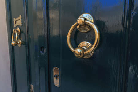 Teal color doors and two round brass door knockerの写真素材