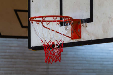 Used basketball backboard, hoop, and net inside of basketball court. Blurred backgroundの写真素材