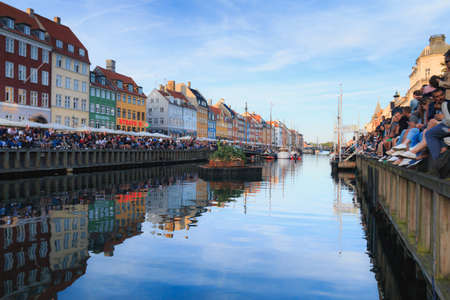 Copenhagen, Zealand Denmark - June 23 2019: Many people sit along the edge of the Nyhavn canal waiting Saint Johns Eve bonfireのeditorial素材