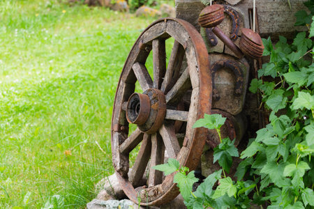 Old wooden wheel in willage near old wodden houseの写真素材