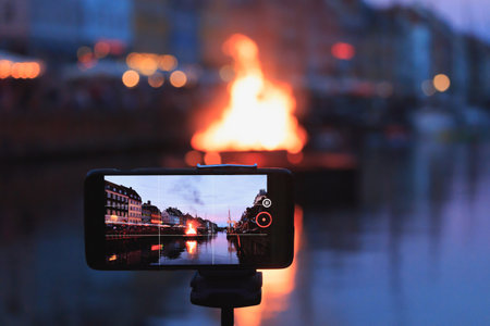 Capturing Burning The witch on bonfire the middle of Nyhavn canal during Saint John's Eve celebration in Copenhagenの写真素材
