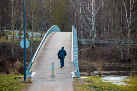 Man walks over the bridge in Panevezys park Lithuania Europe at winter seasonの写真素材