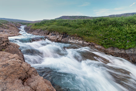 Fast flowing river in Iceland - evening time.の写真素材