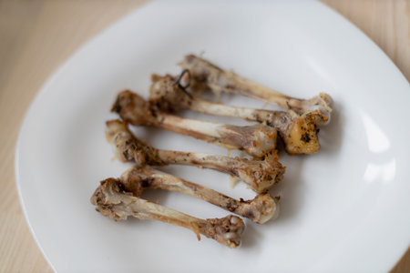 Multiple chicken bones on a white plate.の写真素材