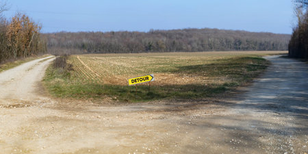 DETOUR sign on the forest gravel road shows to the rightの写真素材