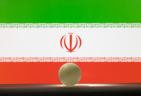 The table tennis ball stands on a surface in front of Iran flag.の写真素材