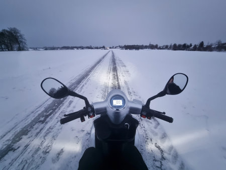 Electric mobility scooter on the road during the winter season in the snow. Lithuania - point of viewの写真素材