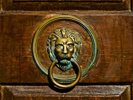 Old metal door nob on the wooden door.