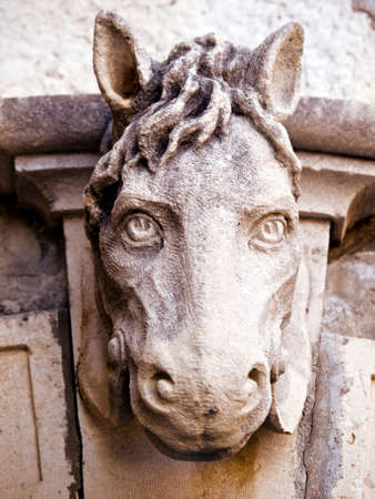 Old horse head sculpture made of stone at entrance of a house. Old Mediterranean house entrance in Dubrovnik. Close up.の写真素材
