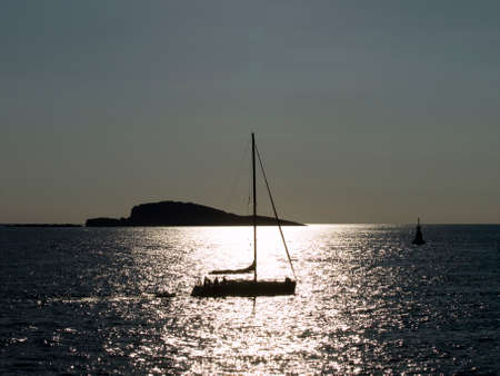 Sunset at Adriatic sea with sailboat passing byの写真素材